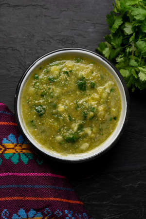 Traditional mexican piquant green sauce with cilantro and onion on dark backgroundの写真素材