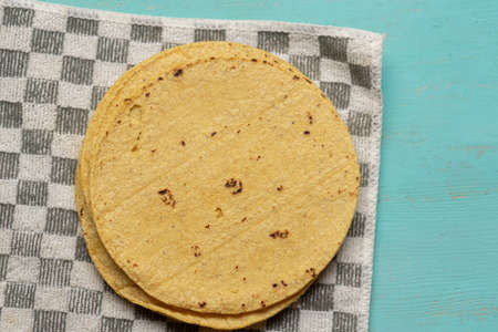 Traditional mexican corn tortillas on turquoise backgroundの写真素材