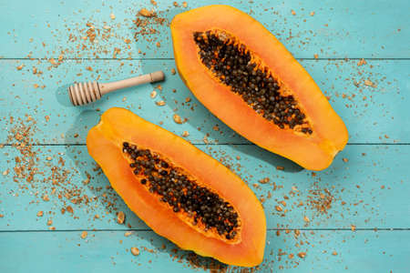 Fresh papaya fruit half on turquoise background