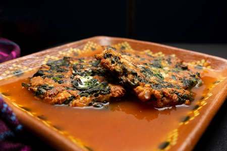 Spinach patties with tomato broth on a dark background. Tasty vegan foodの写真素材