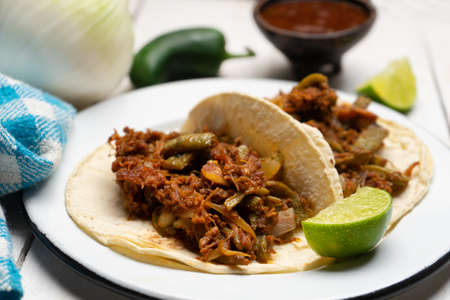 Traditional mexican food. Chilorio and nopales tacos on white background