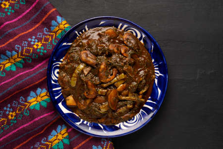 Traditional mexican romeritos with mole sauce and shrimp on a dark backgroundの写真素材