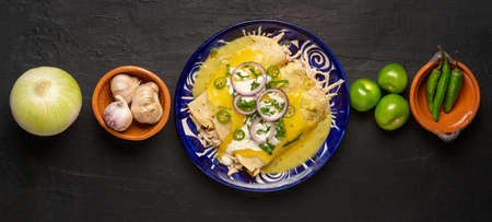 Traditional mexican green enchiladas with chicken and melted cheese