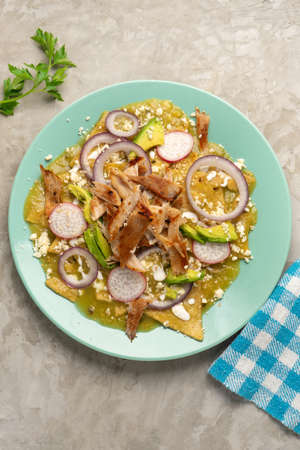 Green chilaquiles with pork meat and cheese. traditional mexican foodの写真素材