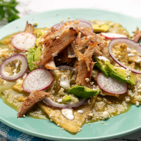 Green chilaquiles with pork meat and cheese. traditional mexican foodの写真素材
