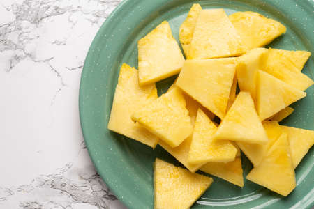 Cutted ripe pineapple fruit on marble background
