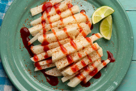 Cutted mexican yam bean also called Jicama with chili powder and chamoy sauceの写真素材