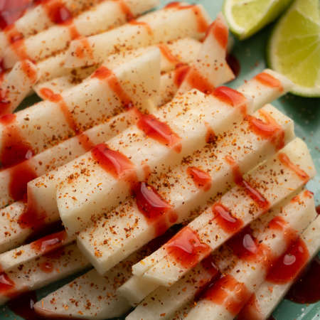 Cutted mexican yam bean also called Jicama with chili powder and chamoy sauceの写真素材