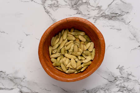 Green pumpkin seeds in a clay bowl