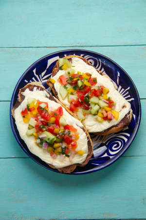 Molletes with Oaxaca cheese and pico de gallo sauce. traditional mexican food