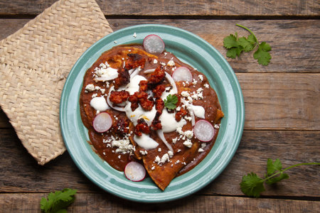 Traditional mexican enfrijoladas with chorizo and fresh cheese