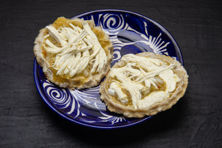 Mexican sopes; fried corn masa bases topped with tomatillo salsa, melted Oaxaca cheese, and onion.の写真素材