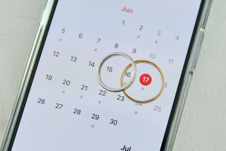 smartphone with wedding rings on the calendar close-up. wedding conceptの写真素材