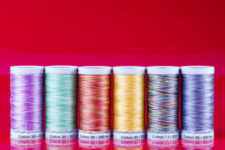 Colored Spools Isolated on Red  Texture Macro 
