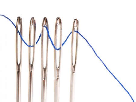 Sewing thread Through the Eye of Five Sewing Needle Isolated on White