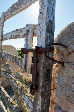 detail of iron latch on typical wooden door, with lichens, on stone wall next to the path, with...