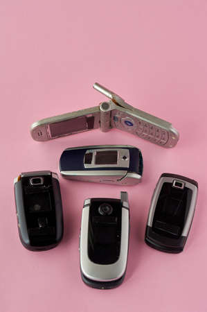 broken mobile phones, recycling technology, early 2000s on pink background and copy space ,.