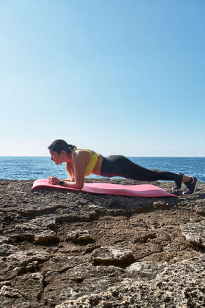 FITNESS WOMAN IN SPORTS SET TRAINING WITH ELASTIC BAND, WEIGHTS, GYM EXERCISES, IN FRONT OF THE...