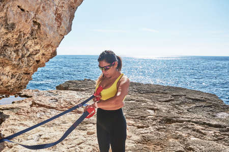 Latin woman, middle-aged, wearing sportswear, training, doing physical exercises, plank, sit-ups,...