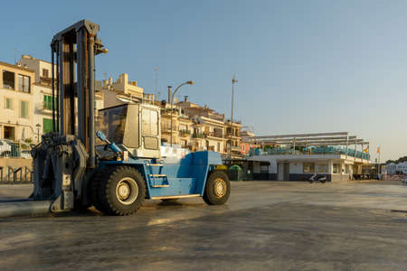 Forklift lowers a boat into the water at a marinaの写真素材