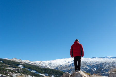 Man standing on the edge of a cliff and contemplating nature's creation in sierra nevada,の写真素材