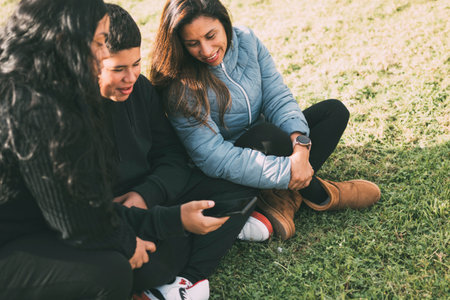 Hispanic family spending quality time together in a local park on a beautiful, sunny day. A teenage...
