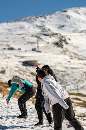 latin family playing in the snow, ski resort, in grenada sierra nevada,の写真素材