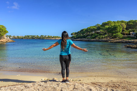 Latina woman, in sportswear on her back, on the shore of the beach looking at the sea breathing deeply.,の写真素材
