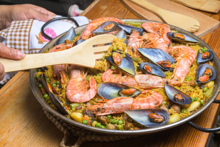 Seafood paella with shrimp and mussels in a pan, ready to be served with a wooden utensil, typical Spanish cuisine, Majorca, Balearic Islands, Spain,の写真素材