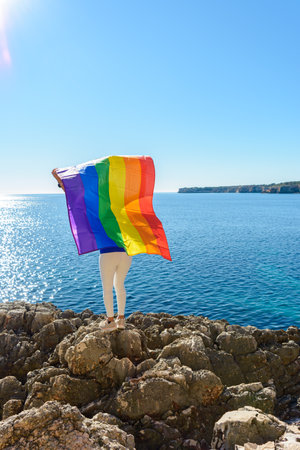woman, middle aged, outdoors waving pride flag, concept of libertat, equalityの写真素材