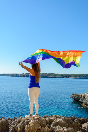 woman, middle aged, outdoors waving pride flag, concept of libertat, equalityの写真素材
