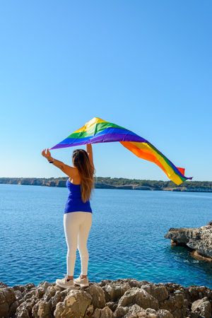 woman, middle aged, outdoors waving pride flag, concept of libertat, equalityの写真素材
