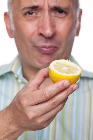 Man grimaces after tasting a lemonの写真素材
