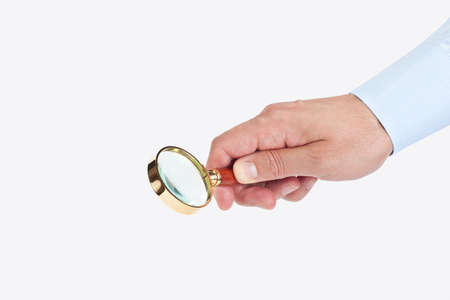 Hand holding a magnifier on white backgroundの写真素材