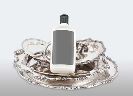 Various pieces of silver and a bottle of polishing product