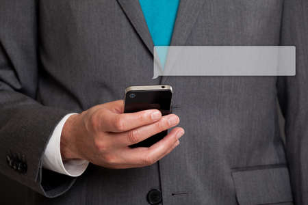 Close up of businessman text messaging on cell phoneの写真素材