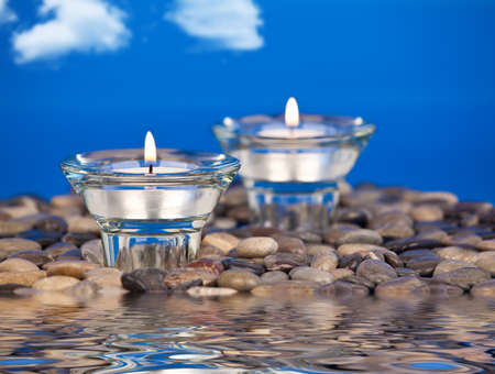 Votive candles placed on rocks in the waterの写真素材