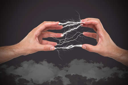 Hands with lightning in the fingersの写真素材