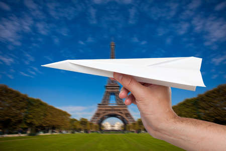 Hand trowing a paper plane in Parisの写真素材