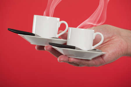 Hand holding espresso cupsの写真素材