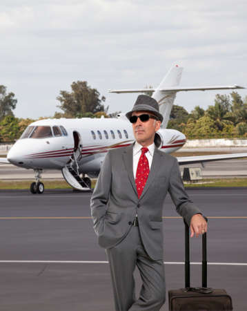 Business man standing next to private jetの写真素材