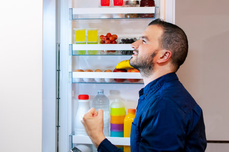 Young man on a diet - Opening the fridge - Healthy foodの写真素材