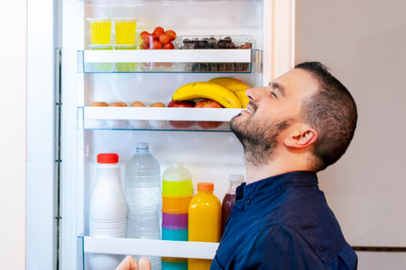 Young man on a diet - Opening the fridge - Healthy foodの写真素材