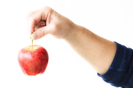 Apple hanging from a woman's handの写真素材