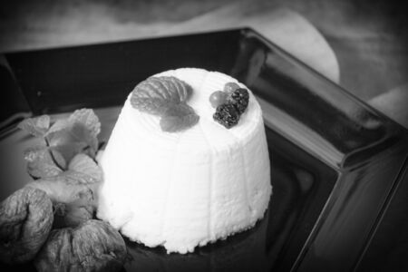 Fantasy of ricotta cheese with berries, dried figs and fresh mintの写真素材