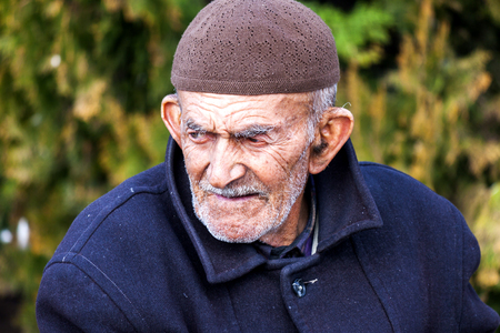 Portrait of an old dirty man on the street