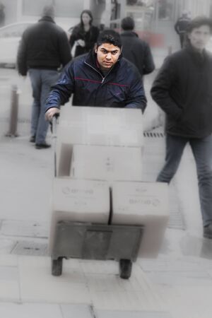 Man is pushing a cart with cardboard boxesのeditorial素材