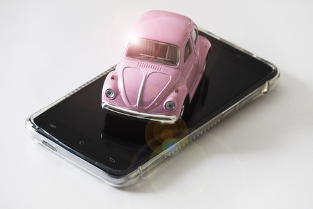 Pink toy car on mobile telephoneの写真素材
