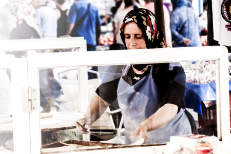 Old turkisth woman is cooking pide at bazarのeditorial素材
