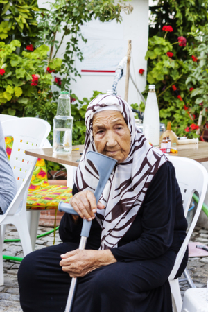 Portrait of an old disabled woman sitting at streetのeditorial素材